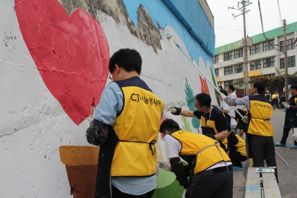 CJ대한통운 건설부문 임직원들이 동작구의 남성중학교 앞에서 벽화를 그리고 있다. 사진=CJ대한통운 건설부문 제공
