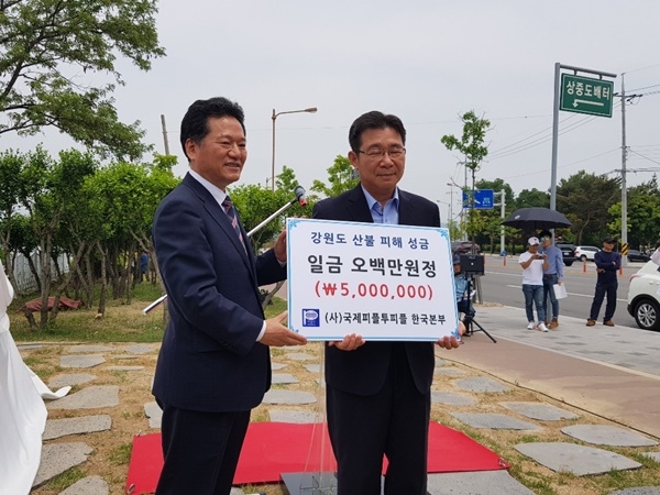 김성재 총재가 윤성보 도 총무행정관에게 강원도 산불피해 성금 증서를 전달하는 모습