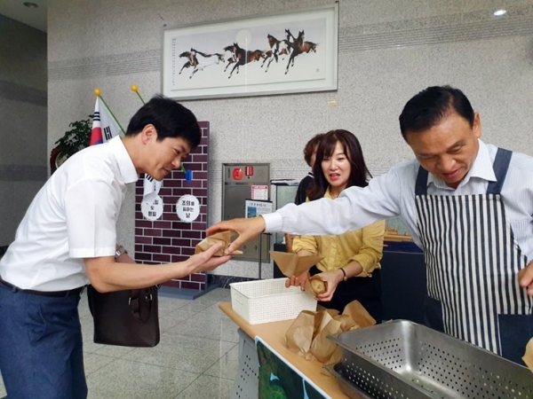 구본영 천안시장이 감자소비 촉진을 위해 직원들에게 삶은 감자를 나눠주는 모습