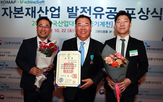 김인동 두산인프라코어 전무(가운데)가 22일 킨텍스에서 열린 ‘2019 한국산업대전’ 개막식에서 한국 자본재 산업 발전에 기여한 공로로 산업포장을 수상했다. 사진=두산인프라코어 제공