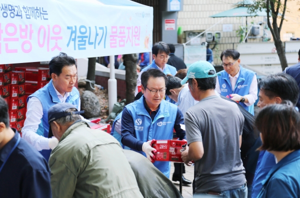 신한생명 임원 봉사자들이 서울역 쪽방상담소 나눔터에서 쪽방촌 거주민들에게 라면박스를 전달하고 있다. 사진=신한생명