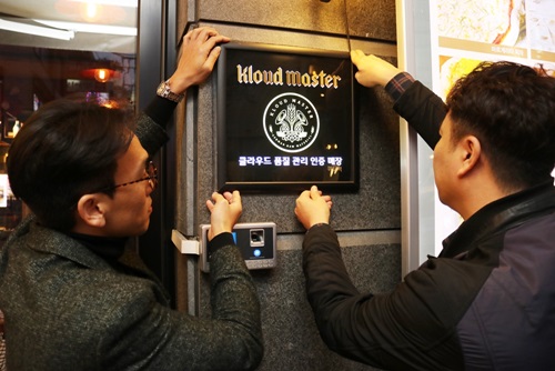지난 8일 '클라우드 마스터' 500호 매장으로 인증받은 서울 강남 '쿼터백'에서 직원들이 마스터 인증 엠블럼을 설치하고 있는 모습.사진=롯데주류 제공