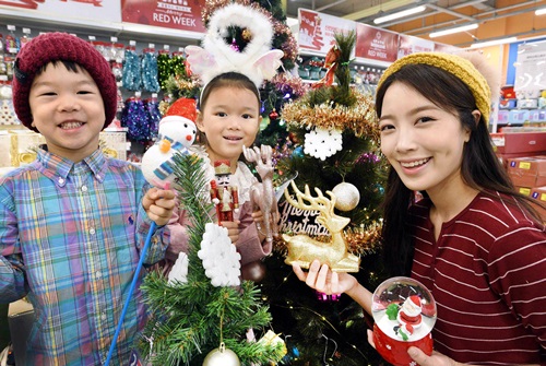 모델이 12일 서울 등촌동 홈플러스 강서점에서 아동들과 함께 크리스마스 트리와 장식품을 선보이고 있다.사진=홈플러스 제공