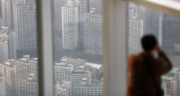 서울 송파구 잠실 롯데월드타워를 찾은 시민이 인근 아파트 단지를 바라보고 있다
