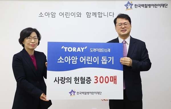 도레이첨단소재 김은주 상무(왼쪽)가 헌혈증 300매를 서선원 한국백혈병어린이재단 사무총장에게 전달하고 있다.