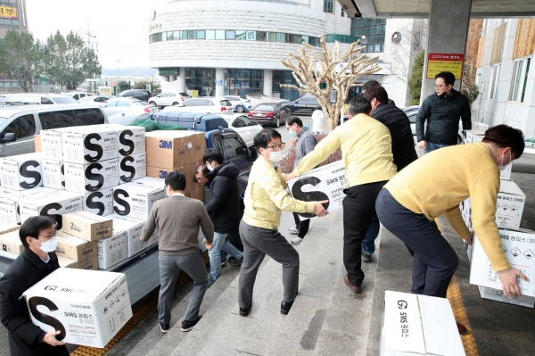차춘심 ㈜심우대표로부터 기부받은 코로나19 예방물품을 시청 현관으로 옮기고 있는 시 직원들