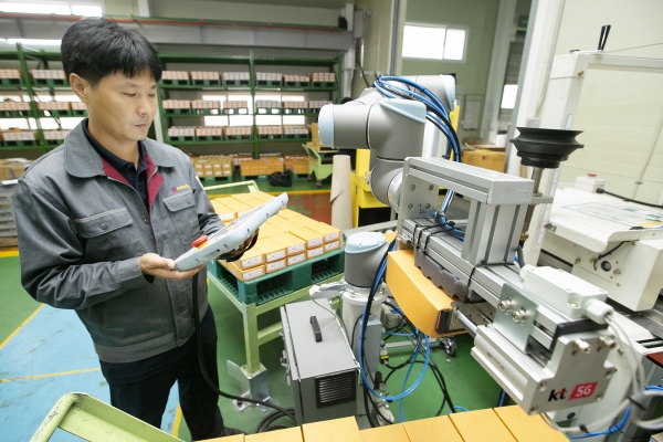 충북 제천에 있는 박원 공장에서 생산직 근로자가 KT 5G 스마트팩토리 코봇과 함께 작업하고 있다. 사진=KT 제공