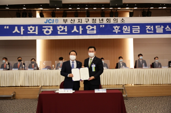 김태진 부산지구JC 회장(오른쪽)과 최용석 골든블루 부회장(왼쪽)이 지역사회 발전 협약서에 서명한 후, 협약서를 들고 기념사진을 촬영하고 있다. 사진=골든블루 제공.