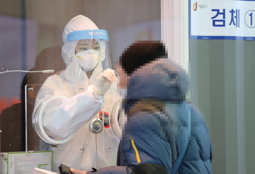31일 오후 서울역 광장에 마련된 신종 코로나바이러스 감염증(코로나19) 임시 선별 검사소에서 의료진이 검체를 채취하고 있다. 사진=연합뉴스