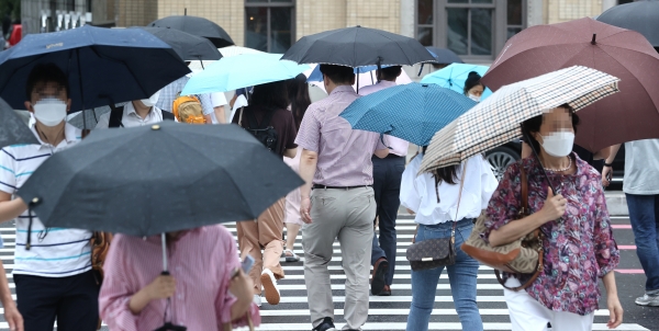 27일 오전 서울 광화문 광장 인근에서 시민들이 우산을 쓴 채 걸어가고 있다. 사진=연합뉴스 제공