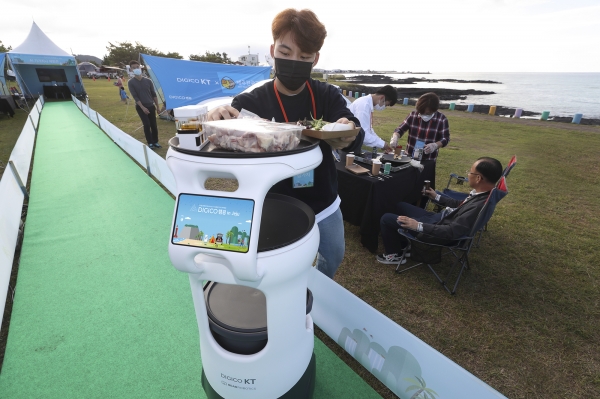 지난 15일 열린 ‘DIGICO캠핑 in Jeju’ 에서 인공지능(AI) 서빙 로봇을 활용하는 모습. 사진=KT 제공