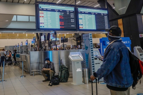 27일(현지시간) 남아프리카공화국 요하네스버그 OR 탐보 국제공항에서 한 승객이 항공편 결항이 표시된 안내판을 보고 있다. 사진=AFP연합뉴스