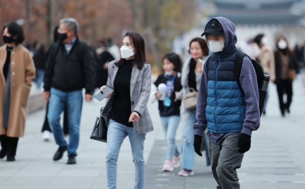 가을비가 내린 뒤 쌀쌀한 날씨를 보이는 13일 오후 서울 광화문광장에서 두툼한 옷을 입은 시민들이 길을 걷고 있다. 사진=연합뉴스