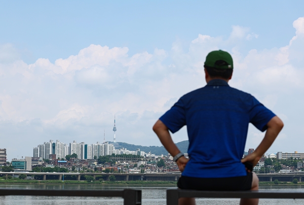 서울 서초구 반포한강공원에서 한 시민이 그늘에 앉아 맑게 갠 하늘을 즐기고 있다. 사진=연합뉴스
