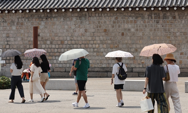 오는 18일 전국 대부분 지역이 체감온도 33도 안팎으로 무더울 예정이다. 사진은 서울 종로구 삼청동길에서 시민들이 양산을 쓰고 이동하는 모습. 사진=연합뉴스