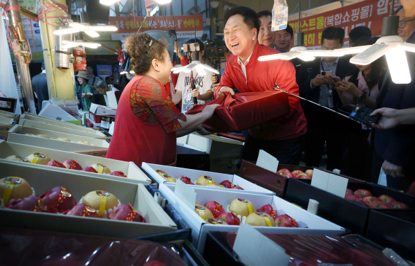 25일 오후 서울 강서구 방신전통시장을 찾은 김기현 국민의힘 대표가 과일을 구입하고 있다. 사진=연합뉴스