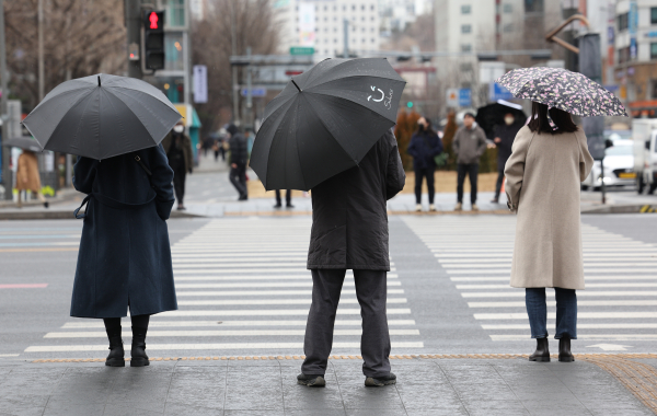 전국 대부분 지역에 눈이나 비가 내린 지난 5일 오후 서울 종로구 광화문광장 인근에서 시민들이 우산을 쓰고 이동하고 있다. 사진=연합뉴스