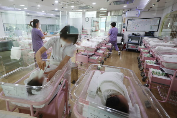 작년 4분기 합계출산율이 사상 처음으로 0.6명대로 떨어진 가운데 서울 시내 한 산후조리원 신생아실에서 관계자가 신생아를 돌보고 있다. 사진=연합뉴스 제공