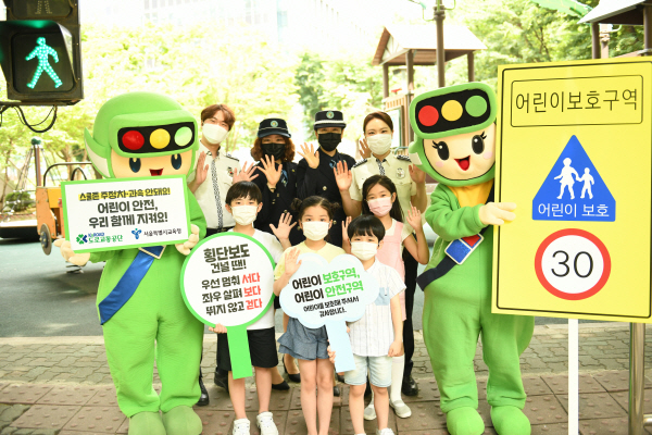 어린이들이 경찰관, 서울녹색어머니연합, 도로교통공단 교통안전교육지도사와 함께 어린이보호구역 교통안전을 위한 사진을 촬영하고 있다. 사진=도로교통공단 제공.